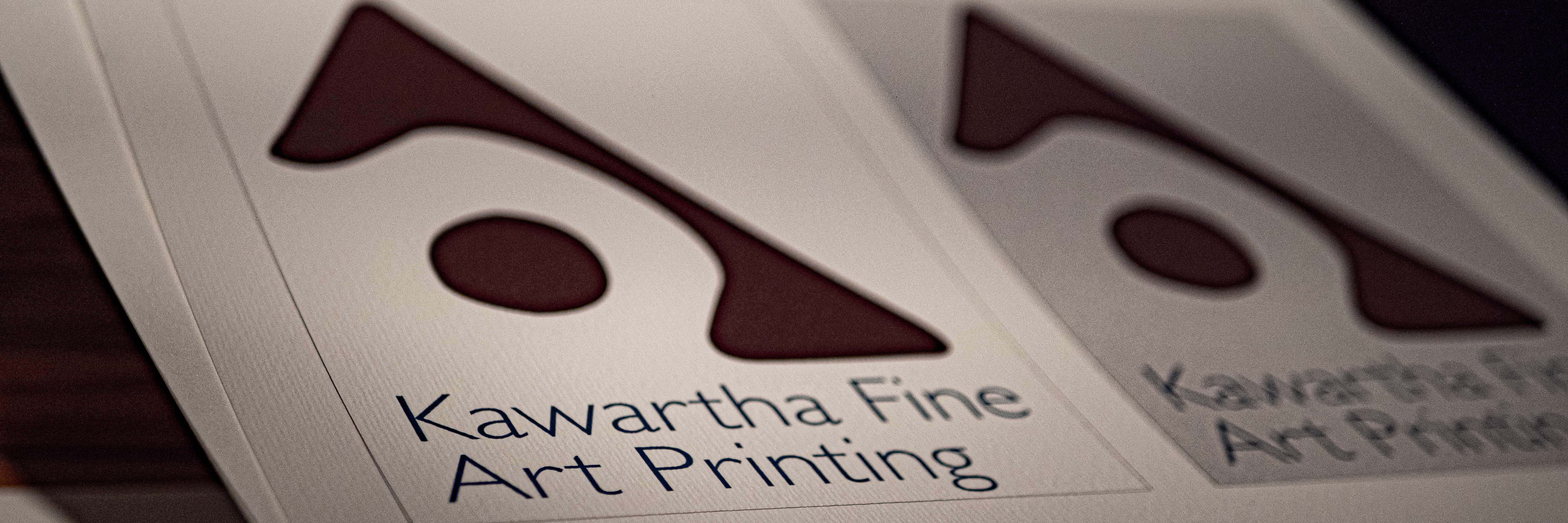 A photograph of two printed company logos on toothy stock.